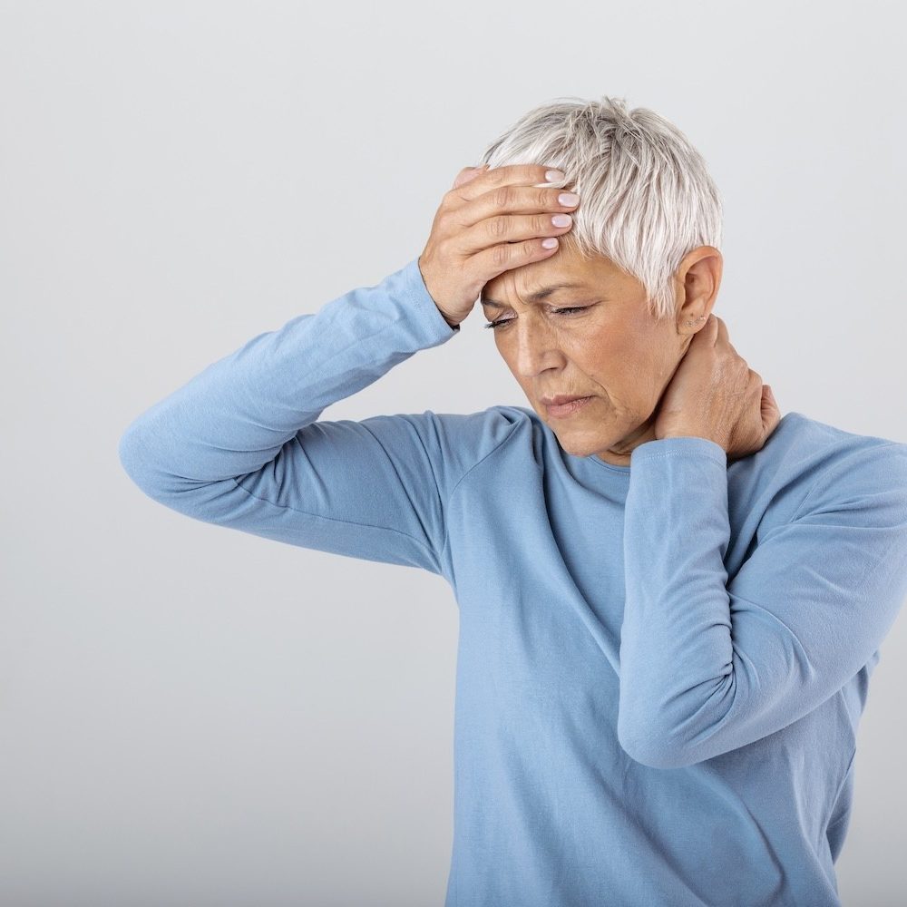 Attack of the monster migraine. Sinus pain. Unhappy Retired Senior Woman holding her head with pain expression . Face of senior woman suffering from headache